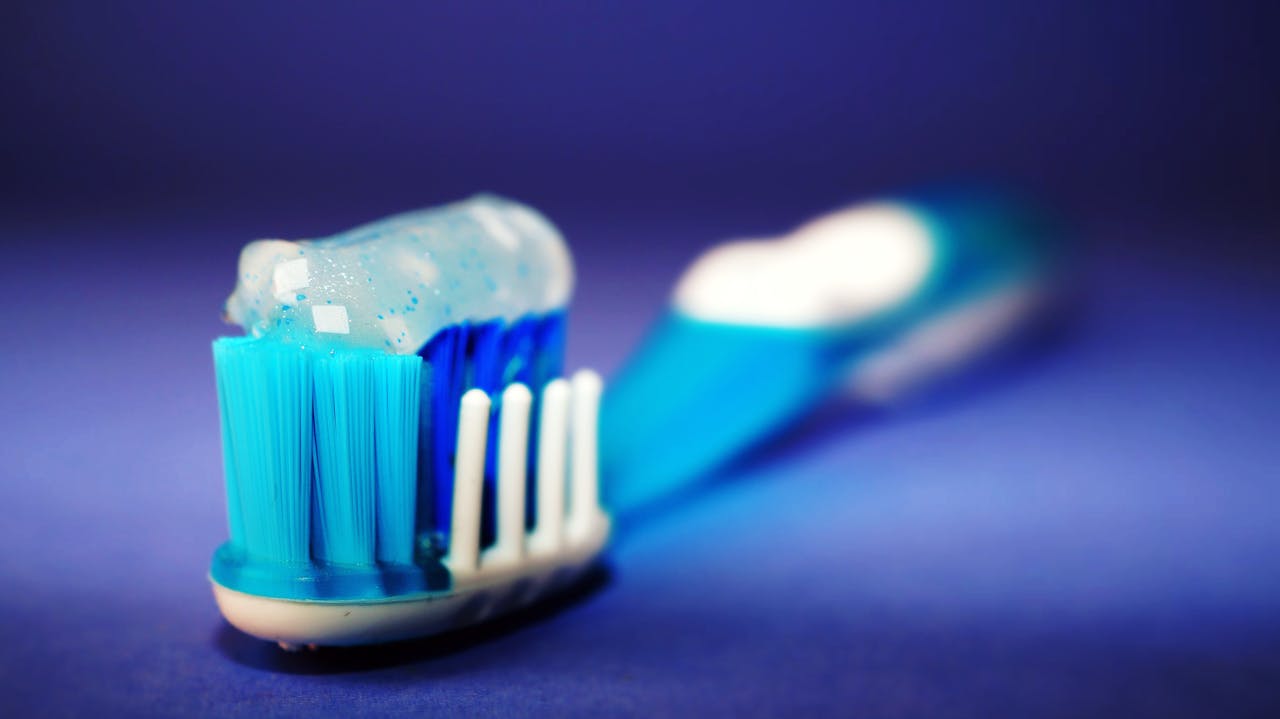 our-services-1 Macro shot of a toothbrush with blue toothpaste and blurred background.